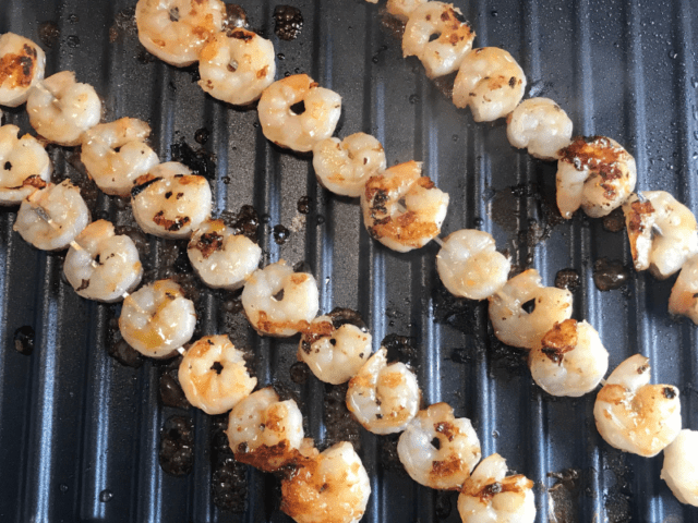 Shrimp are grilled for Hawaiian Shrimp Kabobs.