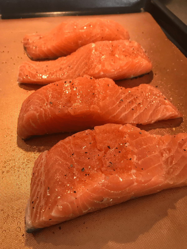 Sprinkle the salmon with salt and pepper and bake it in a 400 degree oven for 13-14 minutes.