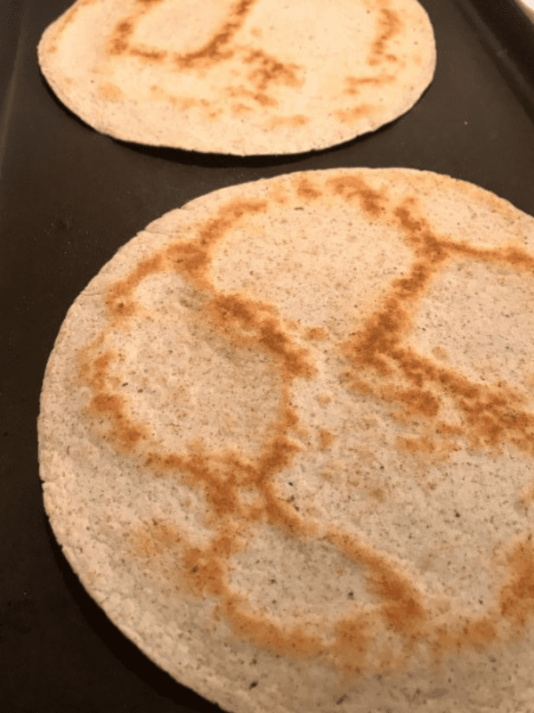 Brown the tortillas in a skillet until they are crispy for a perfect crust for personal pizzas.